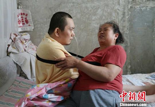 身體日漸衰老的梁青蘭每次幫兒子翻身、坐立，全身的衣物都要濕透一次?！∩忻鱾b 攝