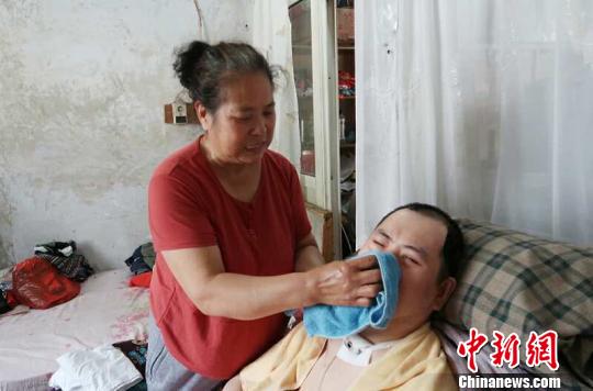每次喂完食物后，梁青蘭都要仔細地幫兒子清理干凈?！∩忻鱾b 攝