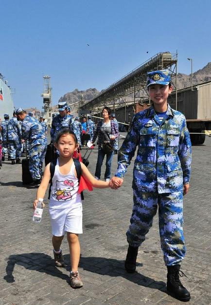 2015年3月，也門，海軍女戰士牽著一名小女孩的手準備登上軍艦。