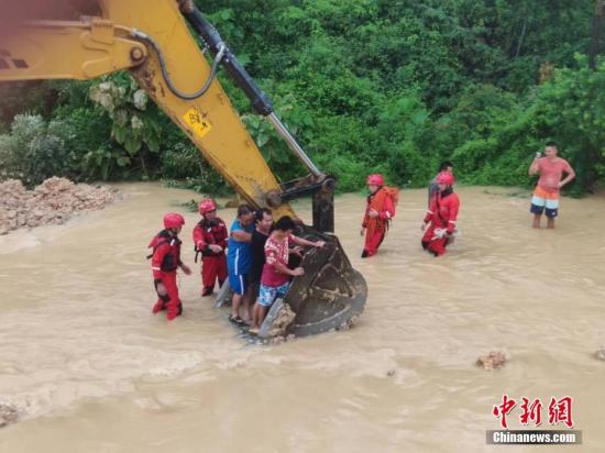 6月16日，因遭遇暴雨襲擊，廣西沿海多處發生嚴重內澇，居民被困。當地消防部門接到求助信息后，先后轉移被困的居民數十人。圖為利用鏟車運送被困居民。