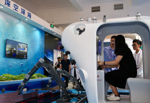 參觀者體驗利用“蛟龍”號使用的機械臂