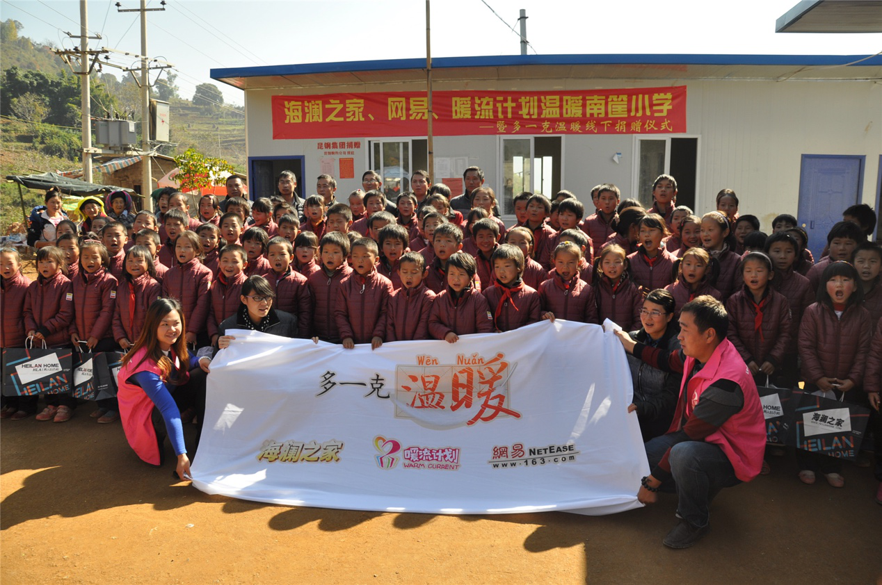 2014年11月20日，“多一克溫暖”公益團隊來到8.3大地震的重災區——云南省昭通市魯甸縣的南筐小學。越過崎嶇山路，將一批又一批暖心羽絨服送到了師生們的手中，也將社會的關懷和愛意傳遞給了這些可愛的人。