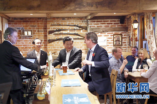 這是會晤結束后，習近平在卡梅倫陪同下乘車前往當地小鎮體驗酒吧文化。新華社記者 鞠鵬 攝